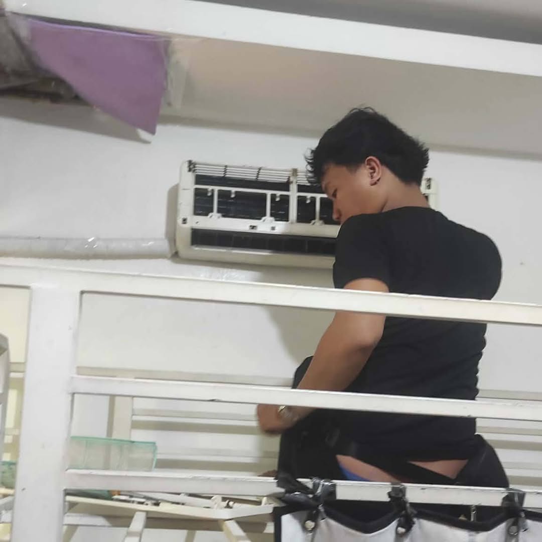 Technician servicing a split-type aircon
